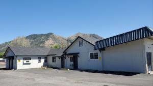 a couple of white buildings with mountains in the background at PineCrest Inn & Suites in Flagstaff