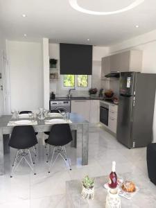 uma cozinha com uma mesa com cadeiras e um frigorífico em Georgianno Sea Apartments em Protaras