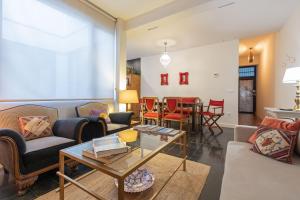 ein Wohnzimmer mit einem Sofa und einem Tisch in der Unterkunft Garci Deluxe Suite by Valcambre in Sevilla