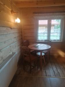 a dining room with a table and chairs in a cabin at Magellan Domki in Cisna