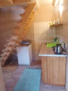 a kitchen with a staircase in a house at Magellan Domki in Cisna