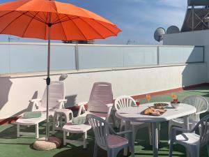 a table and chairs with an umbrella on a roof at Samsara Beach in Port d'Alcudia