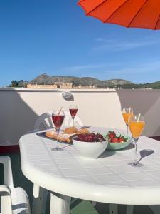 a table with a plate of food and glasses of wine at Samsara Beach in Port d'Alcudia