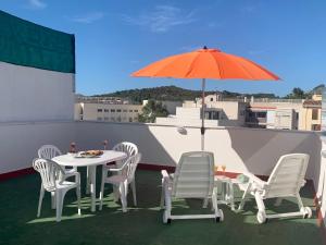 a table and chairs and an umbrella on a roof at Samsara Beach in Port d'Alcudia
