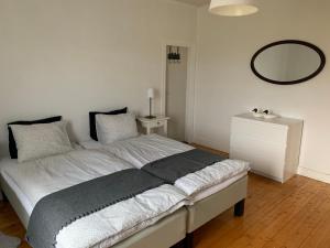 a bedroom with a bed with a mirror on the wall at Villa Västanede in Västanede