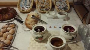 a table with cups of coffee and other pastries at Christeinerhof in Santa Cristina Gherdëina