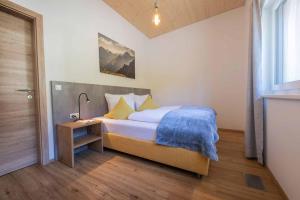 a bedroom with a bed and a table with a lamp at Appartement Medraz in Fulpmes