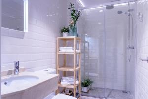 een witte badkamer met een wastafel en een douche bij FerAla Suites Centro A in Granada