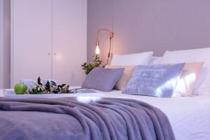 een slaapkamer met een groot wit bed met blauwe kussens bij FerAla Suites Centro A in Granada
