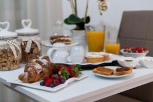una mesa de desayuno con un cruasán, pan y fruta en B.&.B Maison La Dama, en Maruggio