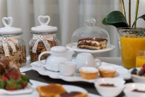 una mesa con un set de té con un pastel y magdalenas en B.&.B Maison La Dama, en Maruggio