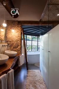 a bathroom with two sinks and a bath tub at Hotel Canto das Águas - Roteiro de Charme in Lençóis