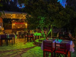 een restaurant met 's avonds tafels en stoelen bij Balalayka Butik Otel in Mugla