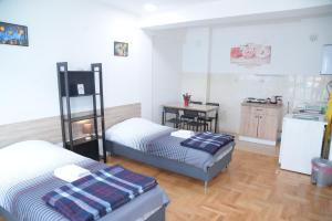 a room with two beds and a kitchen with a table at Petrograd Apart. in Bitola