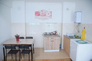 a small kitchen with a table and a table and chairs at Petrograd Apart. in Bitola