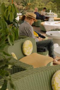 a man wearing a hat sitting in a chair at Condesa df, Mexico City, a Member of Design Hotels in Mexico City