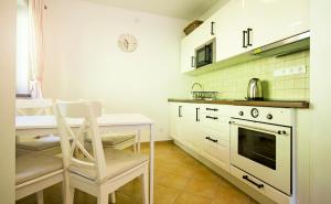 a kitchen with a table and a chair and a stove at Apartmány Hrabovská dolina in Ružomberok