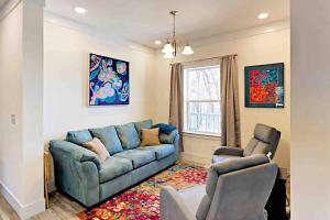 uma sala de estar com um sofá azul e duas cadeiras em Serenity Views Luxury - Close to City & Parkway! em Weaverville