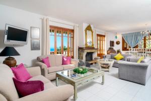 a living room with couches and a tv at Villa Anna in Kallirákhi