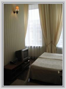 a hotel room with a bed and a tv at Butterfly in Saint Petersburg