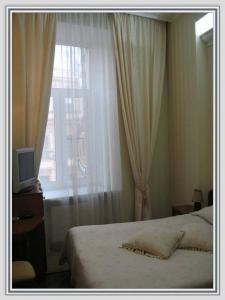 sypialnia z łóżkiem i oknem w obiekcie Butterfly w Petersburgu