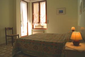 1 dormitorio con 1 cama y 1 lámpara en una mesa en La terrazza tra pini e mare, en San Bartolomeo al Mare