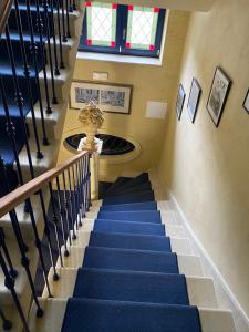 a staircase in a building with blue stairs and a statue at Apartments Merlin in Mariánské Lázně