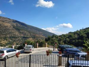 ein Parkplatz mit Autos vor einem Berg geparkt in der Unterkunft Casa rural el Mirador in Trevélez