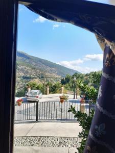 een uitzicht vanuit een kamer met een hek en een geparkeerde auto bij Casa rural el Mirador in Trevélez