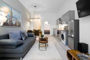 a living room with a blue couch and a kitchen at GreatStay - Lohmeyerstr. 13 in Berlin