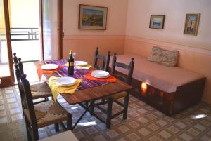 a dining room with a table and a bed at La terrazza tra pini e mare in San Bartolomeo al Mare