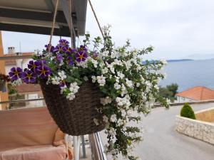 a basket filled with flowers hanging from a balcony at Villa Kovačević in Trogir