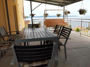 y balcón con mesa y sillas de madera. en Villa Kovačević, en Trogir
