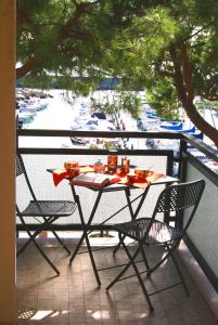 サン・バルトロメーオ・アル・マーレにあるLa terrazza tra pini e mareの港の景色を望むバルコニー(テーブル、椅子付)