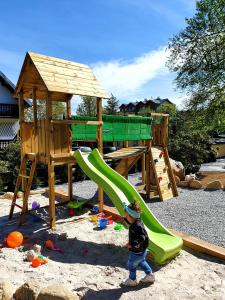 a little boy standing in front of a playground at Walizka Wspomnień in Karpacz