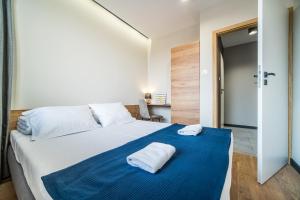 sypialnia z dużym łóżkiem z dwoma ręcznikami w obiekcie Rint - Centrum Zamenhofa Street w mieście Białystok