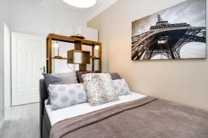 1 dormitorio con 1 cama y una foto de la torre Eiffel en GreatStay - Lohmeyerstr.13 HH., en Berlín