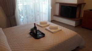 1 dormitorio con 1 cama con 1 botella de vino y toallas en Ideal Family House, en Nea Peramos