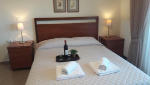 sypialnia z łóżkiem z butelką wina i ręcznikami w obiekcie Ideal Family House w mieście Néa Péramos