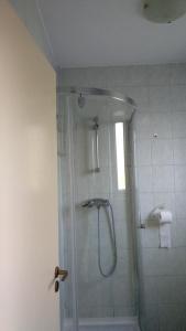 ニーレジハーザにあるPompa Apartmanのバスルーム(ガラスドア付きのシャワー付)