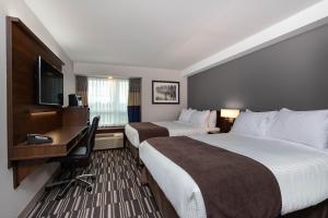 a hotel room with a bed and a television at Microtel Inn and Suites by Wyndham Portage La Prairie in Portage La Prairie