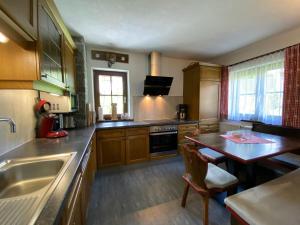 eine Küche mit Holzschränken, einem Tisch und einer Spüle in der Unterkunft Ferienhaus Ötztal-Lodge in Sautens