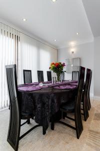 une salle à manger avec une table et des chaises noires dans l'établissement Brooklyn House, à Barnet