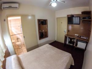 ein Hotelzimmer mit Bett und Badezimmer in der Unterkunft Milão Hotel in Porto Alegre