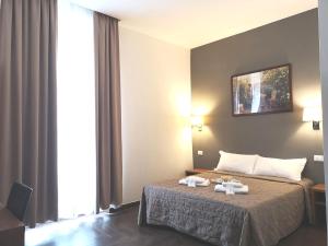 Postel nebo postele na pokoji v ubytování Rome Travellers Hotel