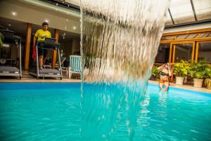 uma pessoa numa piscina com um escorrega aquático em Milão Hotel em Porto Alegre