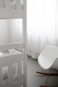a white room with a white chair and a window at Sjövillan B&B in Vaxholm
