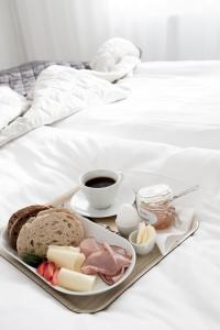 een dienblad met eten op een bed met ontbijt bij Sjövillan B&B in Vaxholm
