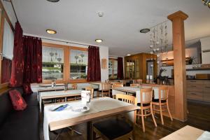 a kitchen and dining room with tables and chairs at Hotel Cabana in Grindelwald