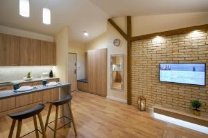 eine Küche mit einer Backsteinwand und 2 Barhockern in der Unterkunft Apartament Ceglany - centrum, prywatne miejsce parkingowe, klimatyzacja in Kielce + 23 Fotos